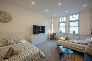 a living room with two beds and a tv at HagenStay Eilpe 1 in Hagen