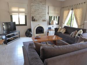 een woonkamer met een bank en een open haard bij Villa Private Heated Pool Sea Views- Sleeps6 in Kouklia