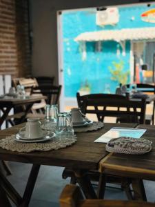 a wooden table with plates and cups on top of it at Pousada VIGLAMO JERI in Jericoacoara