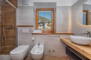 a bathroom with a sink and a toilet and a mirror at B&B Soreghina in Malè +31 photos