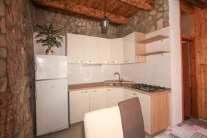 een keuken met witte kasten en een witte koelkast bij Robinson Lenka in Selca kod Bogomolja