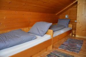 two beds in a cabin with wooden walls at Wallackhaus hütte in Untertauern
