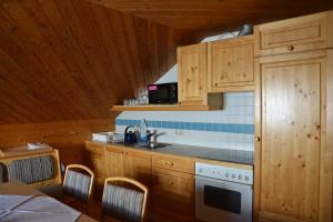 a kitchen with wooden cabinets and a sink and a stove at Wallackhaus hütte in Untertauern +6 photos