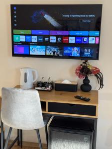 a desk with a chair and a tv on a wall at Casa Antonia Homestay in Şura Mică
