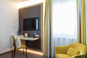 a living room with a yellow chair and a mirror at GORITSCHNIGGs Hotel in Velden am Wörthersee +12 photos