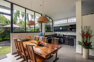 a kitchen and dining room with a wooden table and chairs at Villa Surga in Seminyak