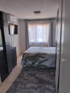 ein Schlafzimmer mit einem Bett und einem Fenster in der Unterkunft Whispering Waves SummerSands in Durban