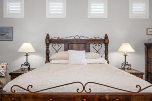 een slaapkamer met een houten bed met 2 lampen bij Desert Oasis home in Reata Pass