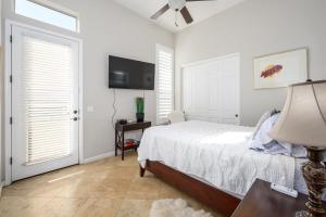 een slaapkamer met een bed en een flatscreen-tv bij Desert Oasis home in Reata Pass +89 foto's