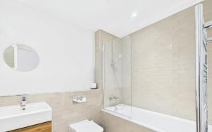 a bathroom with a shower and a toilet and a sink at Modern 2-Bed 2-Bath Apartment in Central Ashford in Ashford