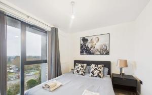 a bedroom with a bed and a large window at Modern 2-Bed 2-Bath Apartment in Central Ashford in Ashford