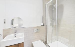 a white bathroom with a sink and a shower at Modern 2-Bed 2-Bath Apartment in Central Ashford in Ashford