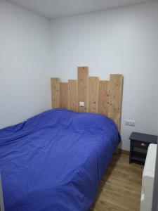 a bedroom with a blue bed with a wooden headboard at Charmant studio Cabine au cœur de Font Romeu in Font Romeu Odeillo Via