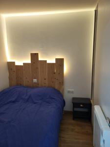 a bedroom with a bed with a wooden headboard at Charmant studio Cabine au cœur de Font Romeu in Font Romeu Odeillo Via +2 photos