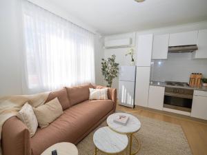 a living room with a couch and a kitchen at Villa Amari - A Sunny Tranquil Home in Melbourne