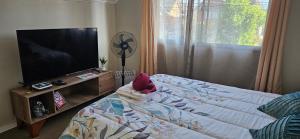 a bedroom with a bed and a flat screen tv at Naturaleza en la ciudad Habitacion Matrimonial con Baño Privado in Machalí