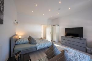 ein Schlafzimmer mit einem Bett und einem Flachbildfernseher in der Unterkunft HagenStay Eilpe 2 in Hagen