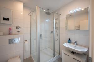 ein weißes Badezimmer mit Dusche und Waschbecken in der Unterkunft HagenStay Eilpe 2 in Hagen