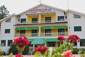 un bâtiment avec des fleurs devant lui dans l'établissement Residencial Pinho Verde, à Mealhada