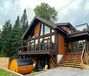 a large wooden house with a large deck and stairs at The Western Spa Sauna Bar & Billiards in Valcartier Station