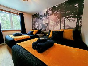 a bedroom with two beds and a large painting on the wall at The Western Spa Sauna Bar & Billiards in Valcartier Station