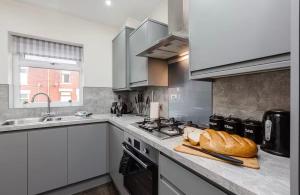 eine Küche mit einer Arbeitsplatte mit Brot drauf in der Unterkunft Norris Stays - Sleeps 7 by M55 in Preston + 14 Fotos