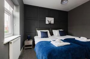 ein Schlafzimmer mit zwei Betten mit blau-weißer Bettwäsche in der Unterkunft Norris Stays - Sleeps 7 by M55 in Preston