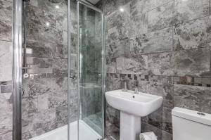 ein Badezimmer mit Waschbecken und Dusche in der Unterkunft Norris Stays - Sleeps 7 by M55 in Preston
