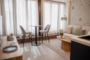 a living room with a couch and a table and chairs at Royar Casa del Reloj - Apartamentos Premium frente Catedral in Jaén