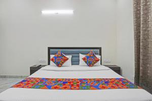 a bedroom with a bed with a colorful quilt on it at FabHotel Winsome Inn in Noida