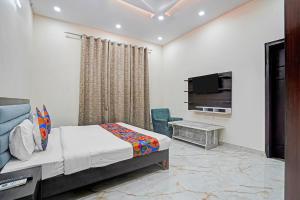 a bedroom with a bed and a flat screen tv at FabHotel Winsome Inn in Noida