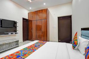 a bedroom with a large bed and a tv at FabHotel Winsome Inn in Noida +19 photos