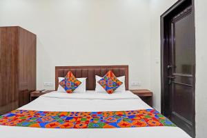 a bedroom with a bed with a colorful comforter at FabHotel Winsome Inn in Noida