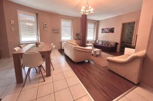 a living room with a table and a dining room at Aqua Apartman in Pécs +16 photos