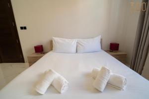 a white bed with two white towels on it at A lovely 1BR studio home in Rabat with WIFI & AC by 360 Estates in Rabat