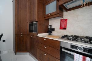 a kitchen with wooden cabinets and a stove at A lovely 1BR studio home in Rabat with WIFI & AC by 360 Estates in Rabat +24 photos