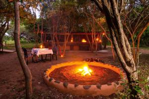 a fire pit in the middle of a yard with a table at Lodge Forest Suite in Hluhluwe +7 photos