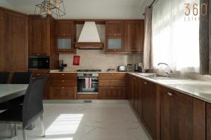 a kitchen with wooden cabinets and a table and a sink at A lovely 1BR studio home in Rabat with WIFI & AC by 360 Estates in Rabat