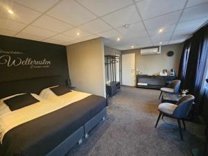 a hotel room with a bed and two chairs at Hotel Café de Sport in Velden