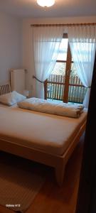 a bedroom with a large bed with a window at Schneiderhof in Steinbach +21 photos