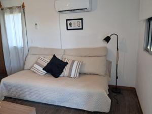 een bank met twee kussens erop in een kamer bij Casa bella in Durazno +3 foto's