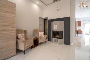 a living room with two chairs and a fireplace at A lovely 1BR studio home in Rabat with WIFI & AC by 360 Estates in Rabat