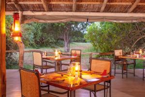 an outdoor dining area with tables and chairs at Lodge Forest Suite in Hluhluwe