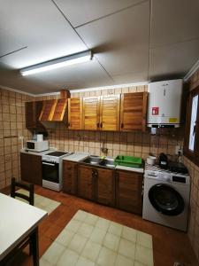 a kitchen with wooden cabinets and a washing machine at Casa Numari in Caudiel