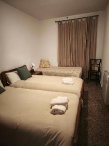 a hotel room with three beds with towels on them at Casa Numari in Caudiel