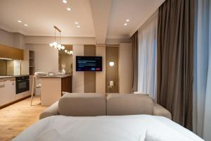 a bedroom with a bed and a kitchen with a tv at Elegant Ivory Studio by Blvd 16B7 - Quiet Garden View in Pipera in Pipera