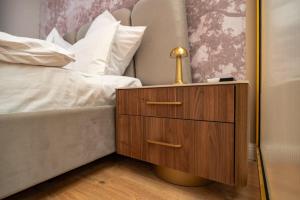 a nightstand with a lamp on it next to a bed at Elegant Ivory Studio by Blvd 16B7 - Quiet Garden View in Pipera in Pipera +40 photos