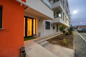 an orange and white building next to a parking lot at Elegant Ivory Studio by Blvd 16B7 - Quiet Garden View in Pipera in Pipera