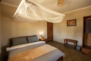 un dormitorio con una cama con mosquitera en Rain Tree Camp, en Chunga