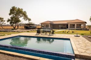 una piscina con una mesa delante de una casa en Rain Tree Camp, en Chunga 206 fotos más